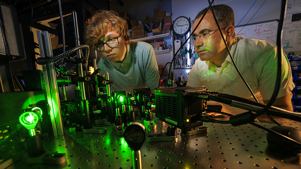 Abdelghani Laraoui (right), assistant professor of mechanical and materials engineering, and Ben Hammons, a first-year student in electrical and computer engineering, adjust a laser in Laraoui's Quantum Sensing & Defect Discovery and Spectroscopy Lab.