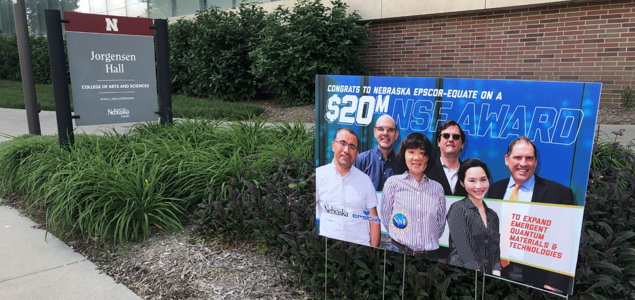 A banner placed outside Jorgensen Hall with a photo of the EQUATE leaders that reads: Congrats to Nebraska EPSCoR-EQUATE on a $20M NSF Award.