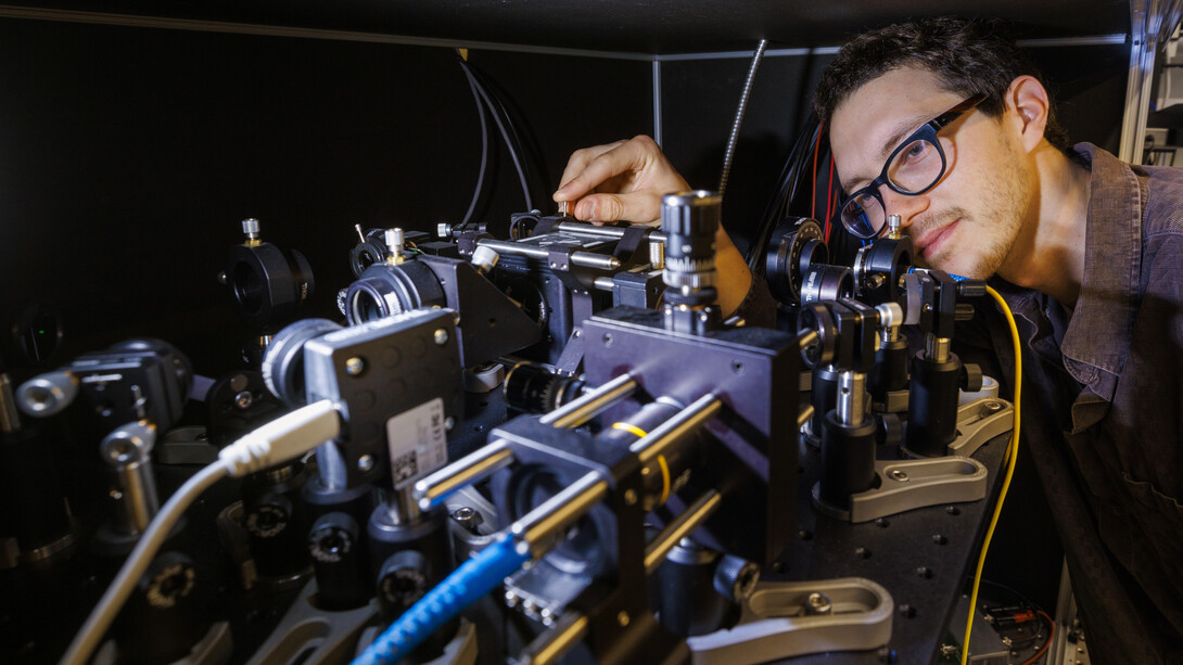 Adam Erickson from Abdelghani Laraoui’s lab in the Engineering Research Center aligns the nitrogen vacancy scanning probe microscope used for the study.