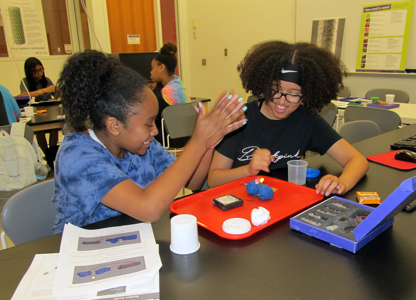 Two middle school girls work on a science experiment during a summer camp