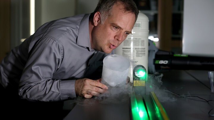 Jeremy Armstrong giving a demonstration with dry ice and a laser. 
