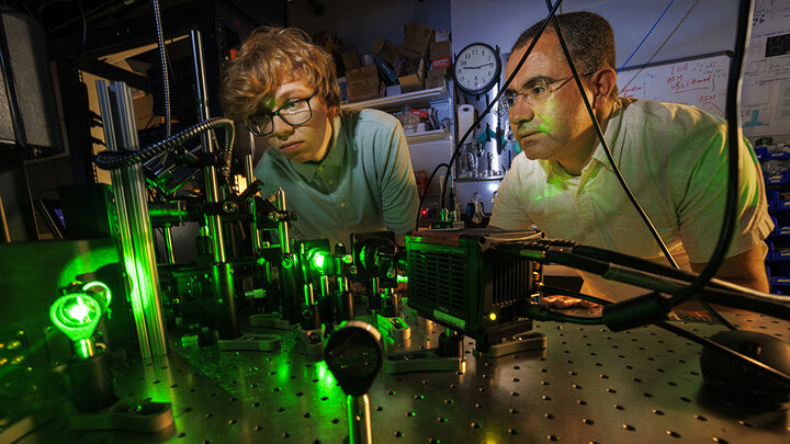 Abdelghani Laraoui (right), assistant professor of mechanical and materials engineering, and Ben Hammons, a first-year student in electrical and computer engineering, adjust a laser in Laraoui's Quantum Sensing & Defect Discovery and Spectroscopy Lab.